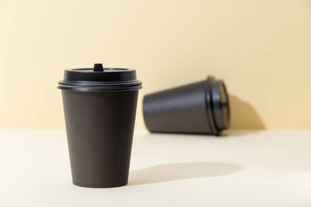 istock Black paper cup for coffee and tea, on a beige background. 1339269462