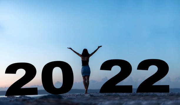 Silhouette of a woman while celebrating new year 2022 stock photo