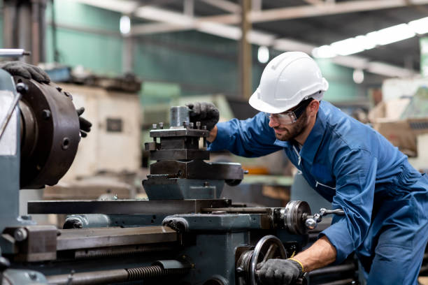 ingeniero industrial trabajador con casco blanco trabajando con maquinaria de producción en la fábrica - torno fotografías e imágenes de stock