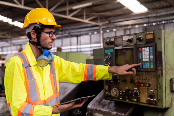 trabajador masculino de la fábrica en el trabajo en la fábrica de la industria. trabajador de ingeniería de fábrica que mantiene la máquina en la fábrica de la industria - manual worker portrait helmet technology fotografías e imágenes de stock