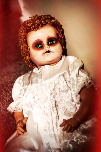 Photo of an old broken doll's face with empty eye sockets.