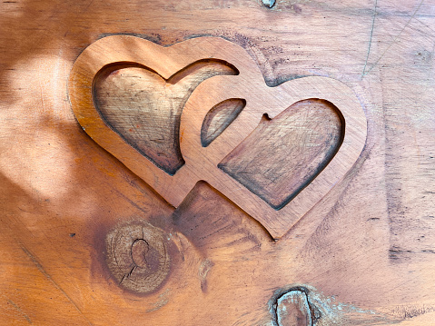 Two carved wooden hearts intertwined