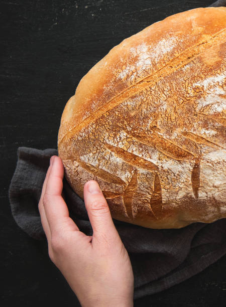 istock Female hand holding freshly baked bread 1339283848