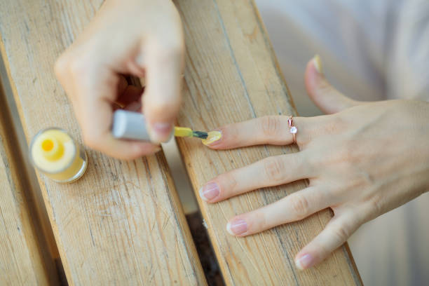 istock girl applying yellow nail polish 1339283993