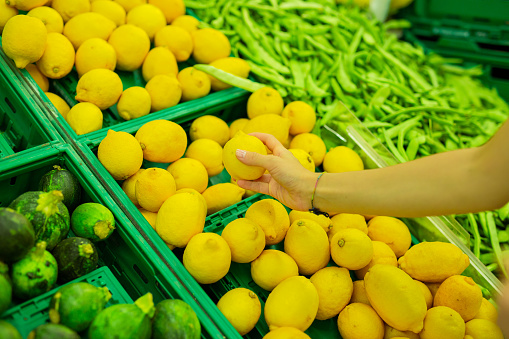 girl choosing lemons from the market