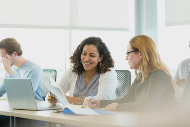 istock Mid adult woman smiles while collaborating on project 1339287202