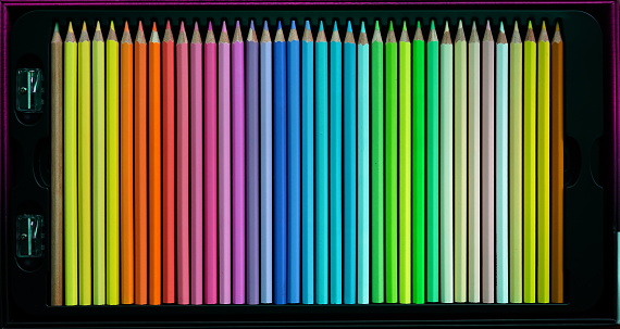 Sharpening colored pencils, black paper background