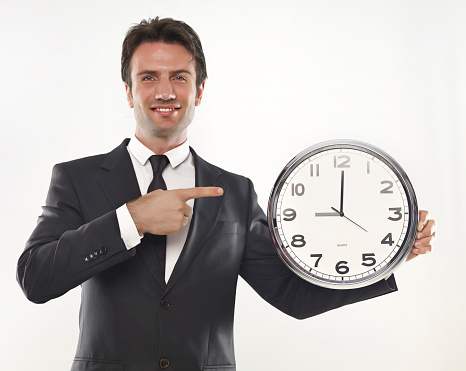 Businessman holding a clock in his hands