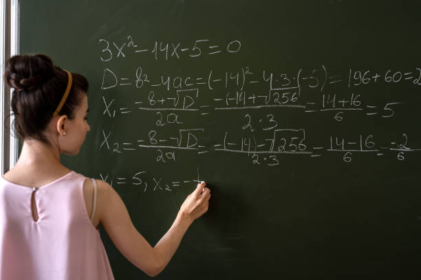 écolière écrivant la formule de mathématiques du lycée avec de la craie au tableau noir - professor adult student chalk drawing formula photos et images de collection