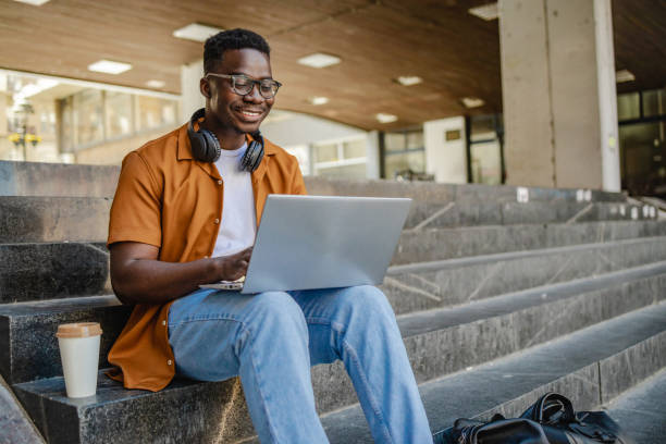 istock Young man uses laptop outdoors 1339291855