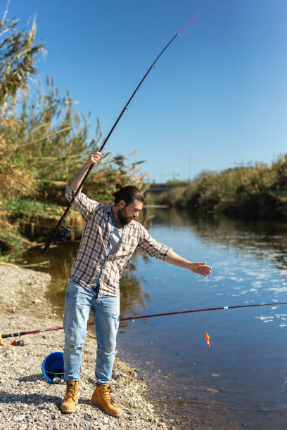 istock Happy fisherman pulls fish out of the river 1339294383