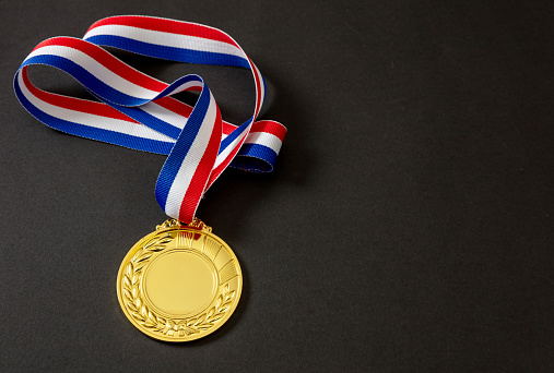 Number one gold medal. Champion first place winner athlete. Prize in sport trophy award and red and blue ribbon isolated on white background. Blank space and laurel wreath, template