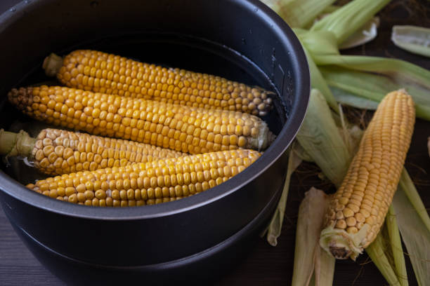 식탁에 물이 있는 냄비에 옥수수를 생 - corn on the cob corn cooked boiled 뉴스 사진 이미지