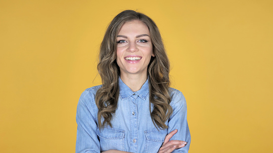 Smiling Young Girl Isolated on Yellow Background