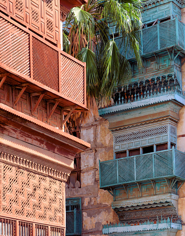 Jeddah, Mecca Region, Saudi Arabia: of hedjazi architecture in Al Balad district, Nadalah Ibn Khalid Lane - building with arabian closed balconies (rawasheen / mashrabiyas), Historic Jeddah, the Gate to Makkah, UNESCO world heritage site. Red Sea coastal coral building tradition, with multiple influences. Thanks to the Hajj pilgrimage, the population of Jeddah was multicultural; Muslims from Asia, Africa and the Middle East had settled here.