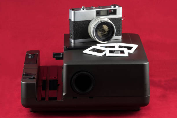 istock Old Slide Projector with Slides and Old Film Camera on a Red Background 1339302130