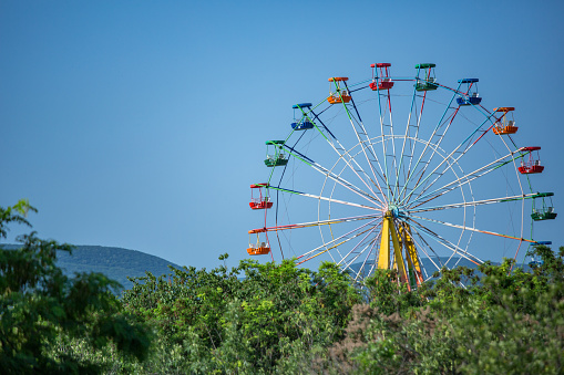 Ferris wheel in the park against the blue sky