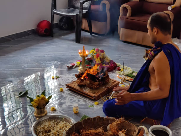 un prete indiano indù o uomini bramini che fanno pooja o pregano (ganapathi homam) in casa con materiali e prodotti alimentari vegetali. - rama foto e immagini stock