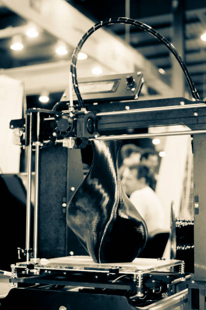 istock 3D printer printing a model in the form of black vase close-up. 1339305597