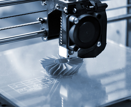 La impresora 3D imprime formas azules en un backgroun azul photo