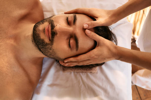 istock Relaxing anti-stress head massage. Handsome man relaxes in a massage parlor during head massage, top view 1339307566