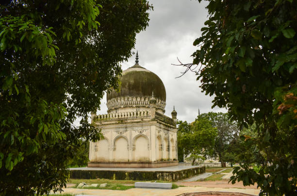 istock Antique Islamic Architectural Art Pointed Arches Seven Tombs Dome and Blue Sky Green Trees 1339312906