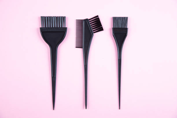 Black plastic brush for hair coloring isolated on pink background