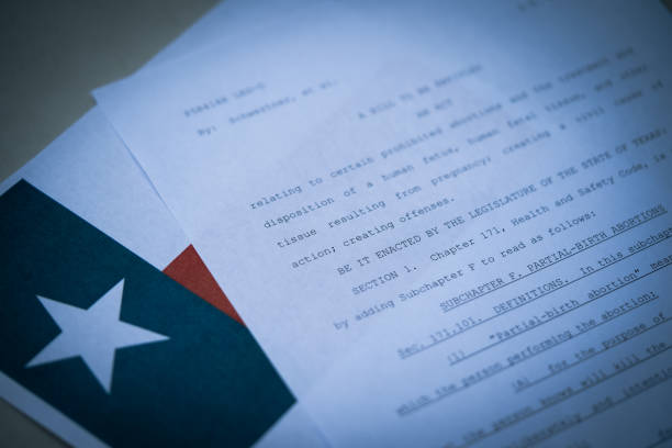 Close up view of Texas Abortion Law (TX SB8) next to the flag of Texas state. stock photo