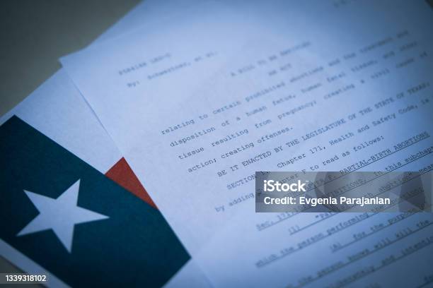 Close Up View Of Texas Abortion Law Next To The Flag Of Texas State Stock Photo - Download Image Now