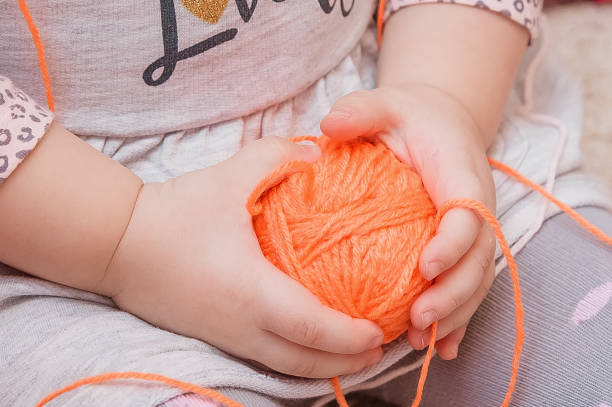 istock A small child is holding a ball of thread in his hands. 1339320533