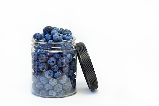 Blueberry in jar with lid on white background