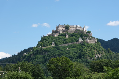Launsdorf, Austria - July 9, 2021: Burg Hochosterwitz. A shot on the move from the driver window of an electric car. Sunny summer day. POV first person view shot on a mountain road