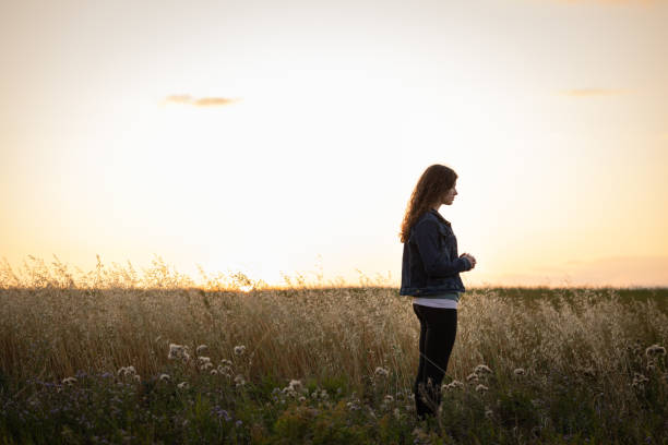 młoda kobieta modląca się o zachodzie słońca - teenagers only lake summer sunlight zdjęcia i obrazy z banku zdjęć