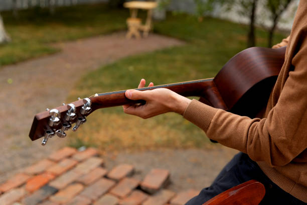 istock young man sits at the table and plays the guitar 1339334963