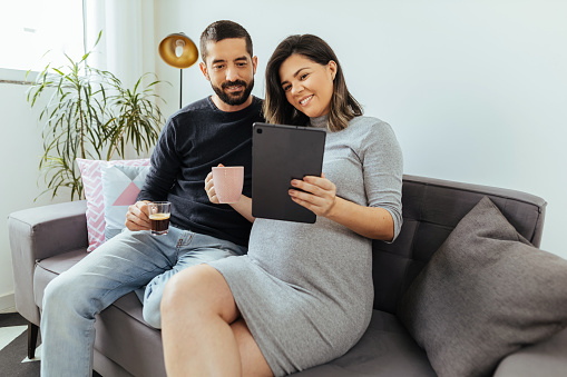Adult couple expecting a baby spending time together at home.