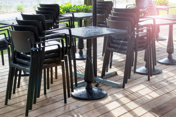 istock Outside summer cafe standing stacked chairs and table covered with rain drops 1339341045