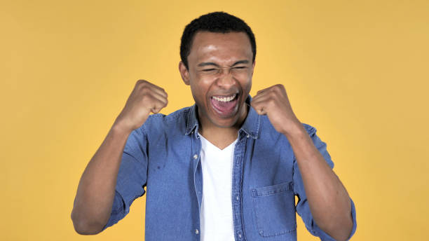 istock Young African Man Celebrating Success Isolated on Yellow Background 1339341539