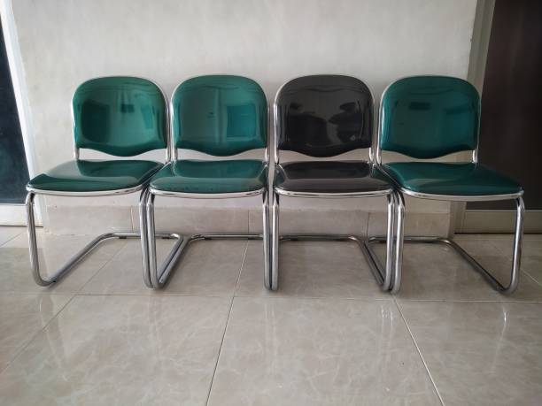 istock Three green chairs and one black chairs between of them 1339344100