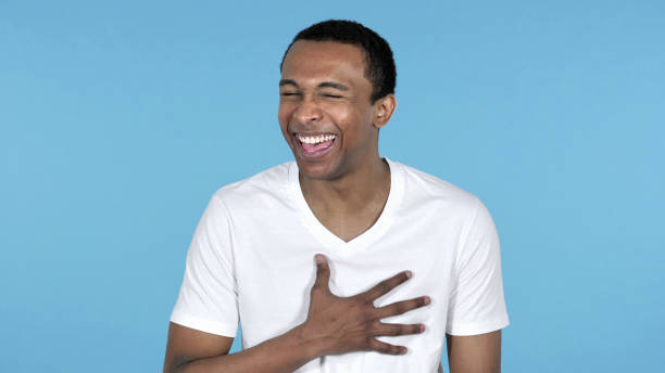 istock Funny Laughing Young African Man Isolated on Blue Background 1339344129