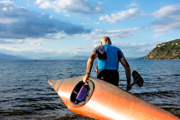 starszy mężczyzna przygotowuje się do spływu kajakiem - blue kayak zdjęcia i obrazy z banku zdjęć