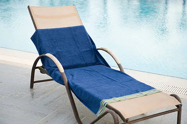 Beach chair with towel near the swimming pool