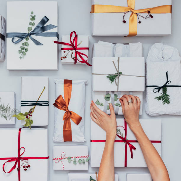 istock Christmas Theme: Top View of Female Hands Packaging Christmas Presents 1339349985