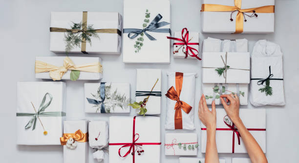 istock Christmas Theme: Top View of Female Hands Packaging Christmas Presents 1339349988