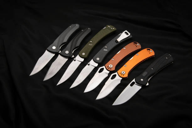 istock Various folding pocket knives on a dark background. A versatile pocket tool and self-defense tool. 1339352665