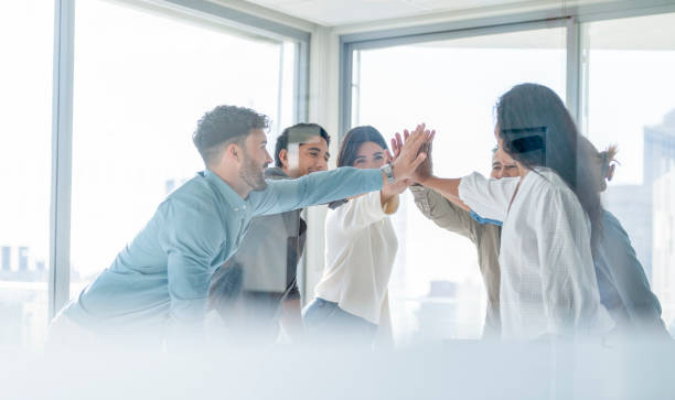 istock Business team celebrating success with a high five. 1339357903
