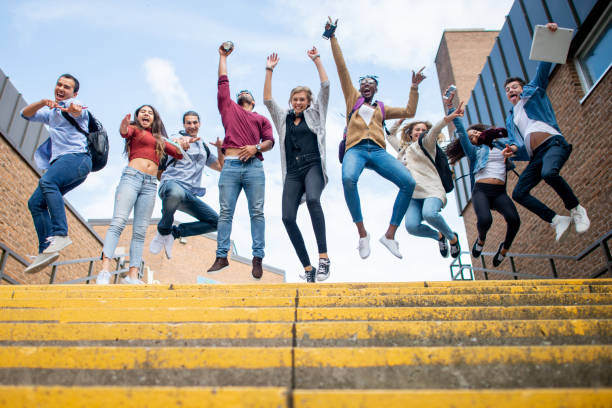 istock Multi ethnic group of students jumping in the air 1339358393