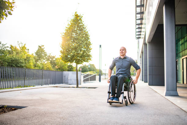 istock Business Professional Rolling Past Camera in Wheelchair 1339362644