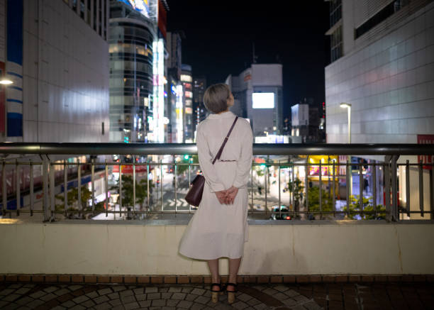 young woman looking at night city view from footbright - camel back imagens e fotografias de stock