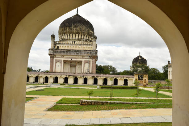 istock Antique Islamic Architectural Art Pointed Arches Seven Tombs Dome and Blue Sky Green Trees 1339373383