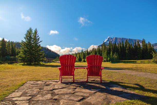 istock Red Adirondack Chairs Looking Out Over A Summer Park 1339376411